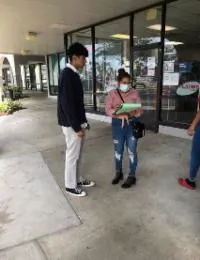 Canvasser speaking with a voter outside a storefront